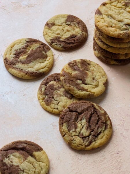 Peanut butter chocolate swirl cookies stacked on a pink backdrop