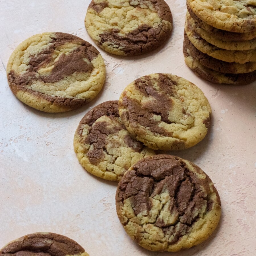 Peanut butter chocolate swirl cookies stacked on a pink backdrop