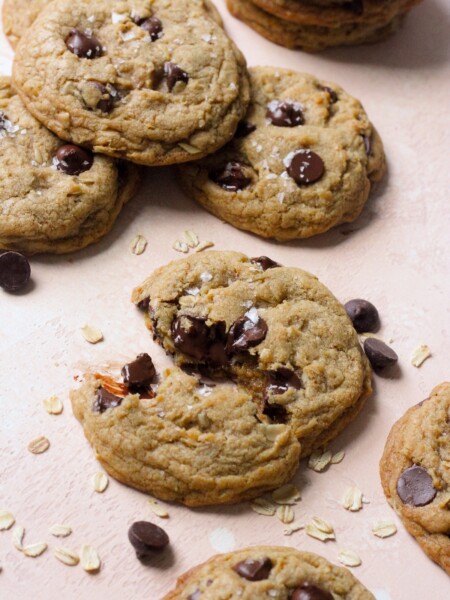 Brown butter oatmeal chocolate chip cookies on a pink backdrop