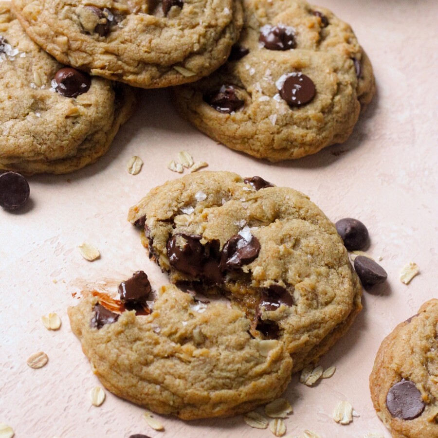 Brown butter oatmeal chocolate chip cookies on a pink backdrop