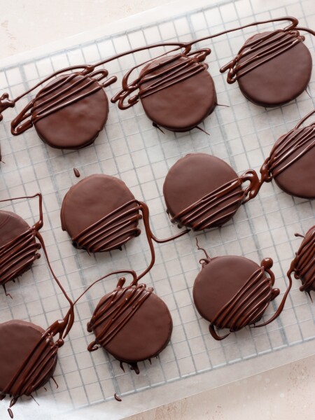 Thin mint cookies on a wire cooling rack on a pink backdrop