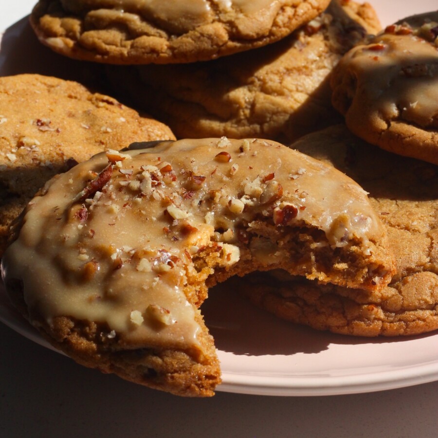 Maple pecan cookies on a pink plate in bright light on a white counter