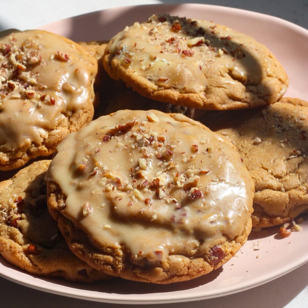Maple pecan cookies on a pink plate in bright light on a white counter