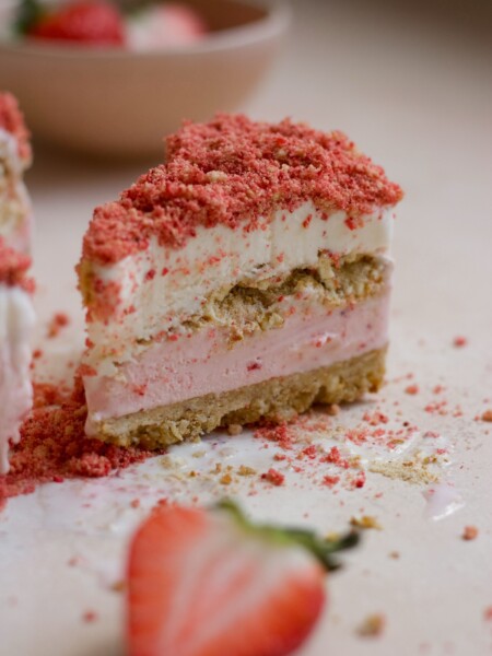 Strawberry crunch ice cream cake on a pink backdrop.