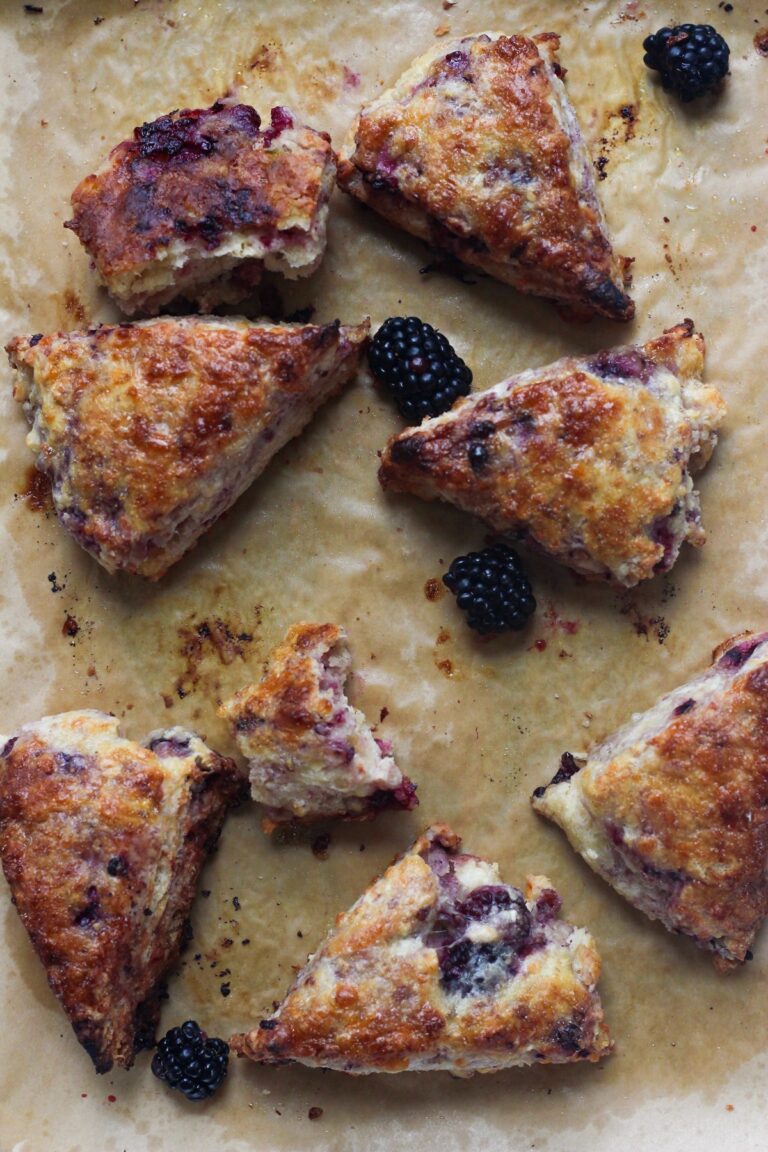 Blackberry habanero scones on a baking sheet on a backdrop.