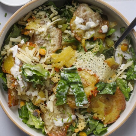 Crispy potato salad on white tile backdrop.