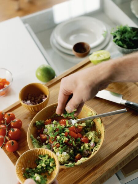 Tyler, author of Schmidty Bakes, making chunky guacamole on cutting board.