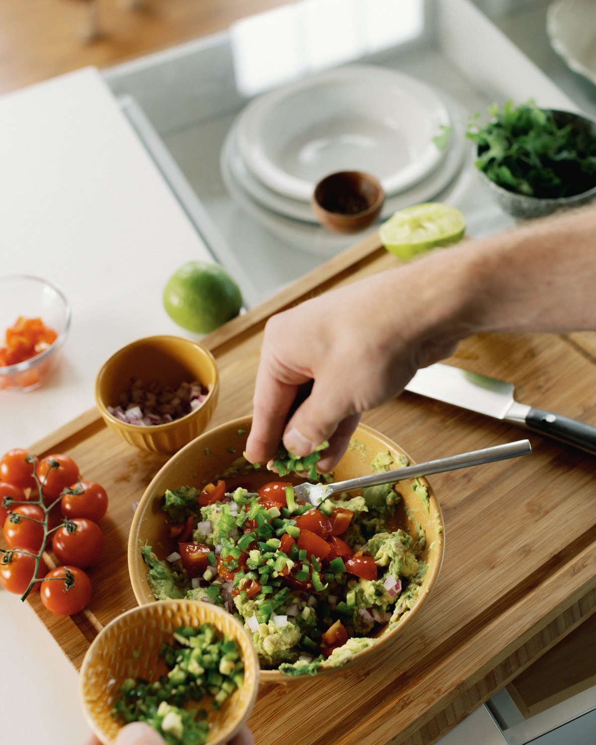 Tyler, author of Schmidty Bakes, making chunky guacamole on cutting board.