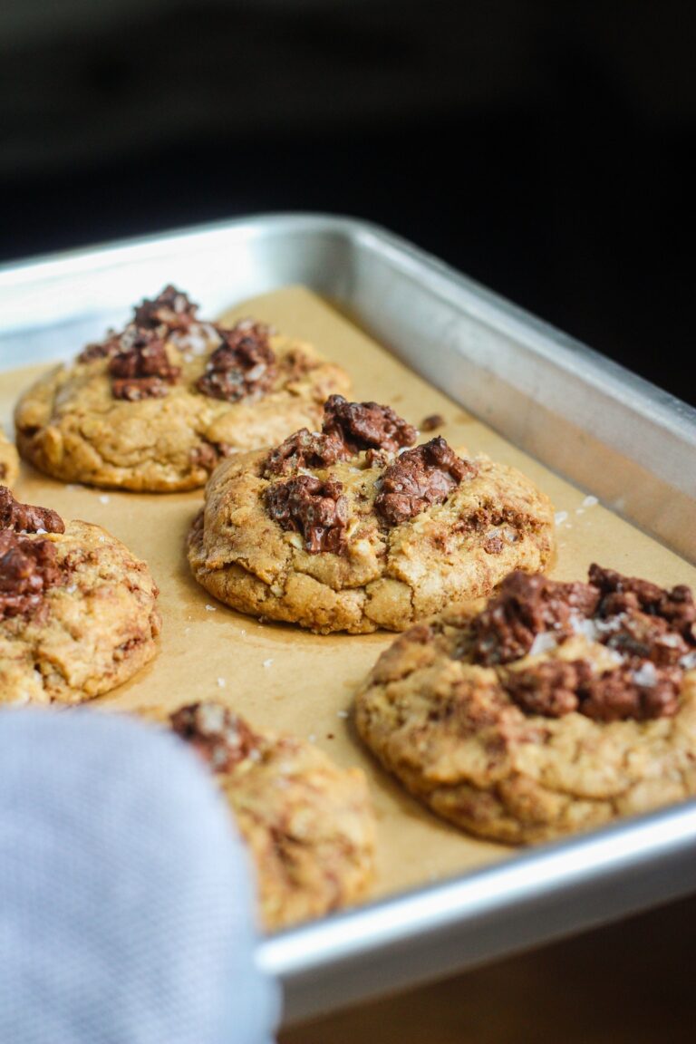 Tray of baked chocolate crunch cookies and an oven mitt.