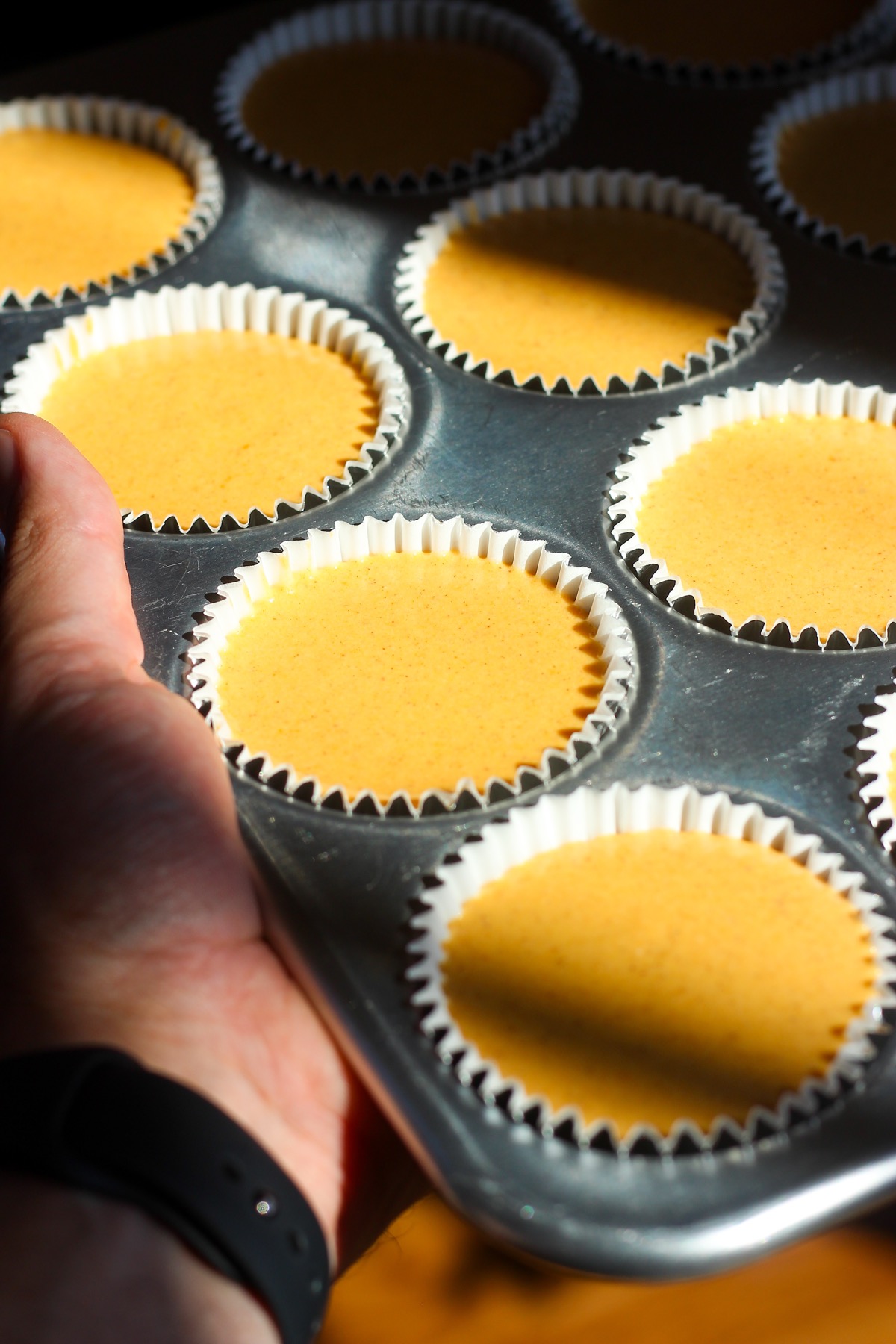 Mini pumpkin cheesecakes in muffin pan.