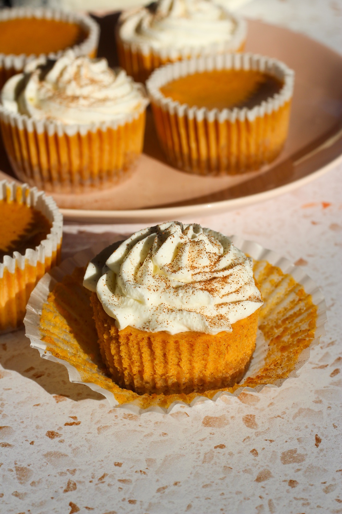 Mini pumpkin cheesecakes on a backdrop.