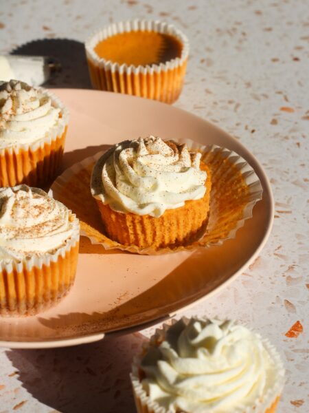 Mini pumpkin cheesecakes on a pink plate.