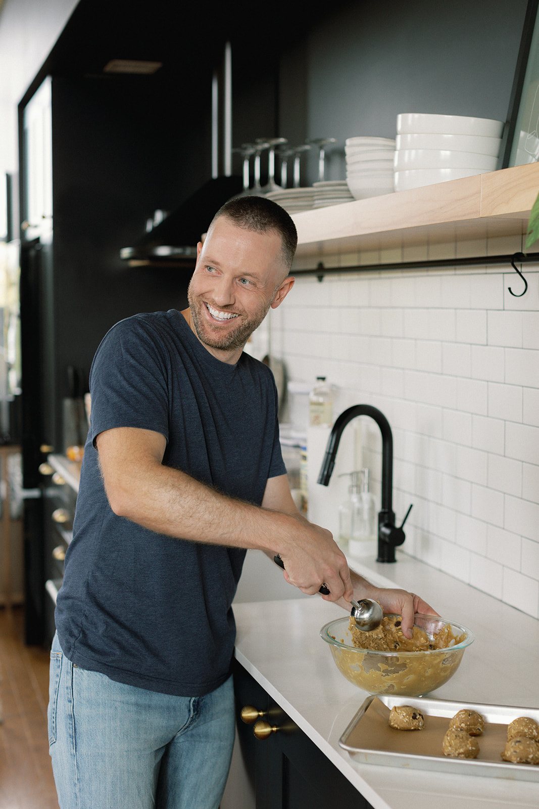 Tyler, author of Schmidty Bakes, cooking in the kitchen and smiling.