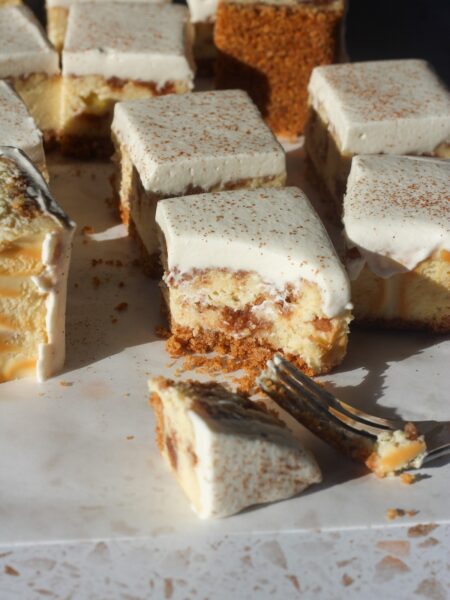 Close up shot of a cinnamon swirl cheesecake bar with a fork and a bit taken.