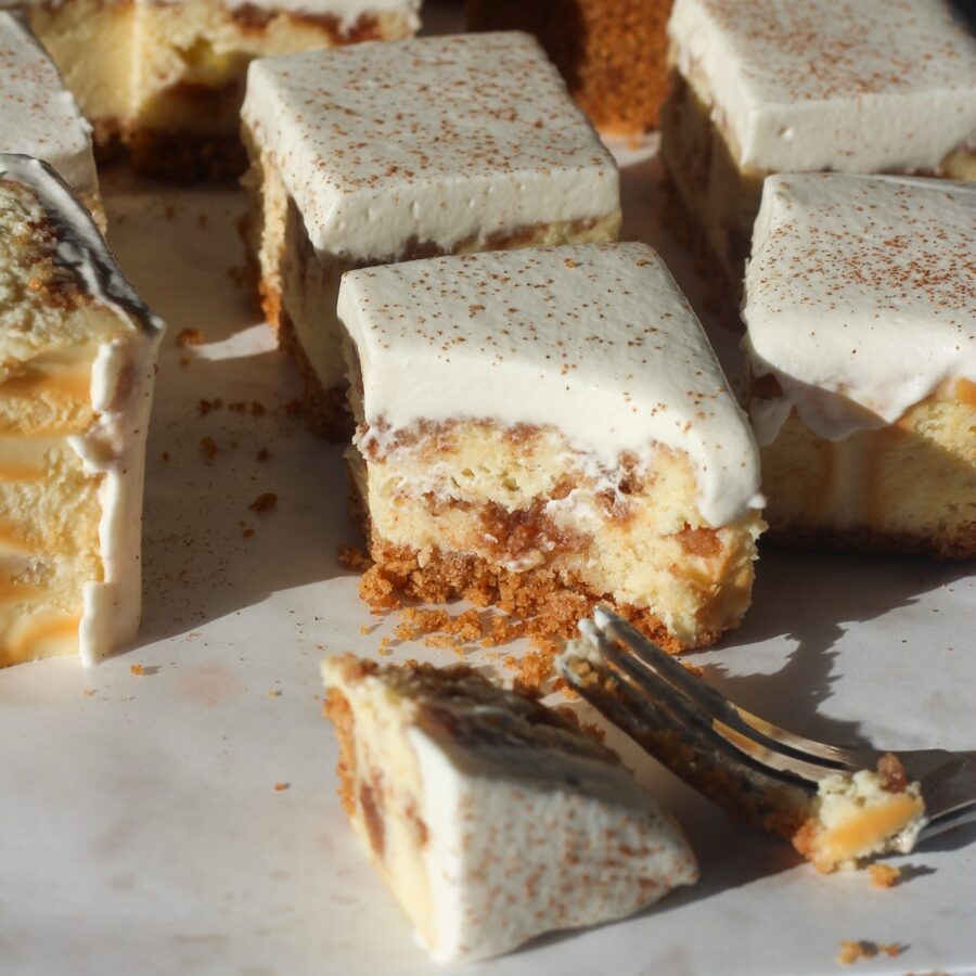 Close up shot of a cinnamon swirl cheesecake bar with a fork and a bit taken.