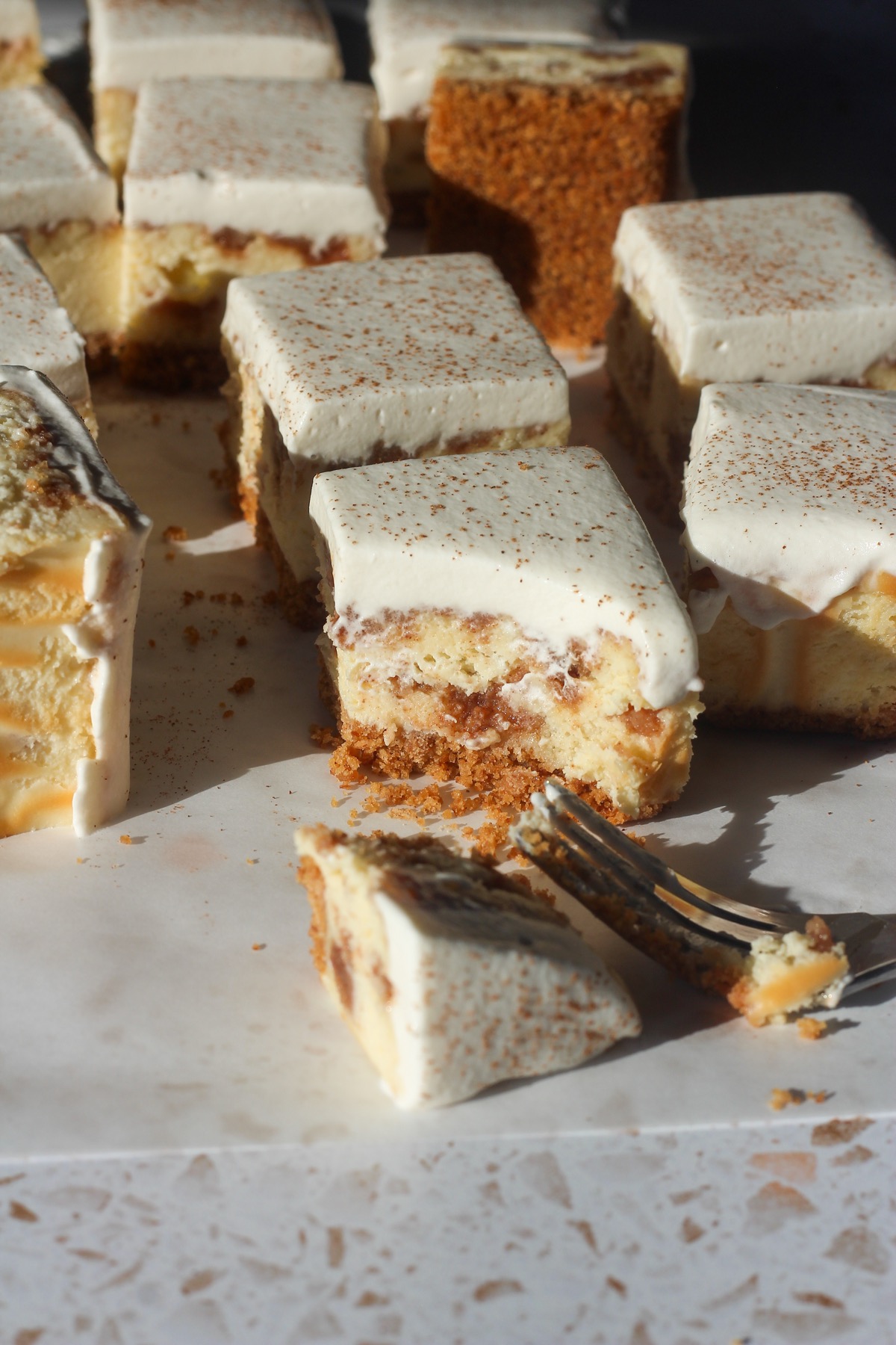 Close up shot of a cinnamon swirl cheesecake bar with a fork and a bit taken.