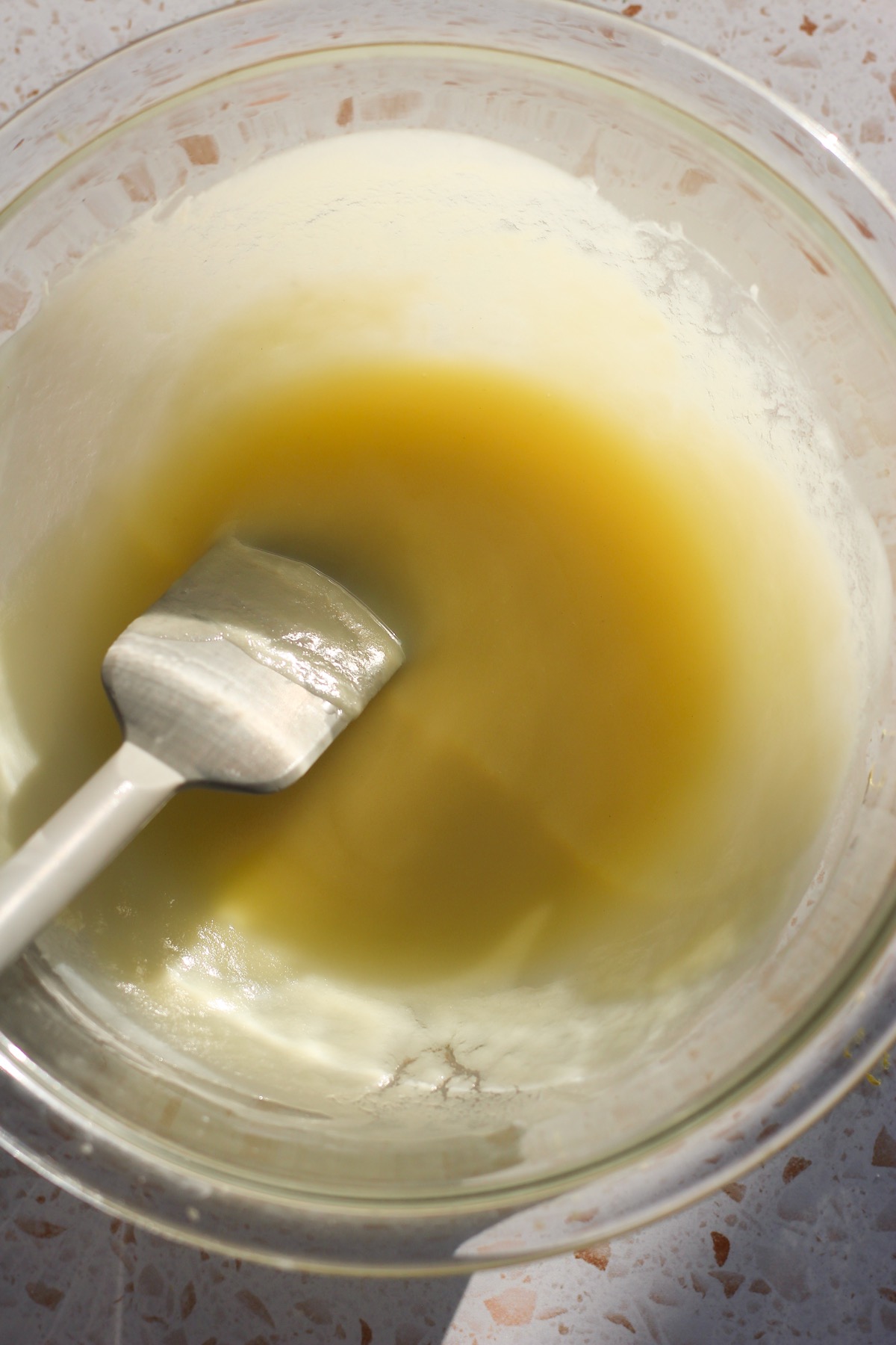 White chocolate and butter melted in a glass bowl.