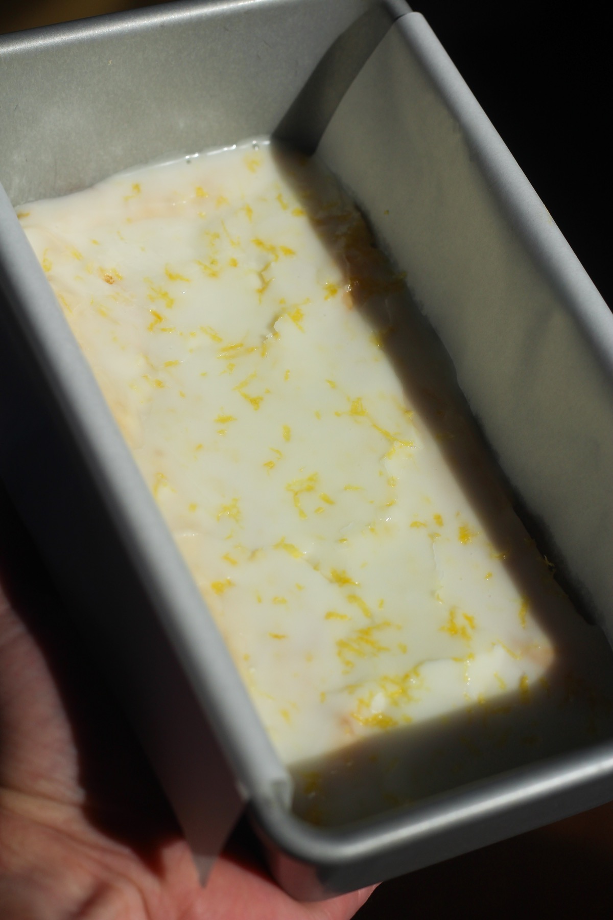 Lemon brownies in direct sunlight in a 9x5 pan.