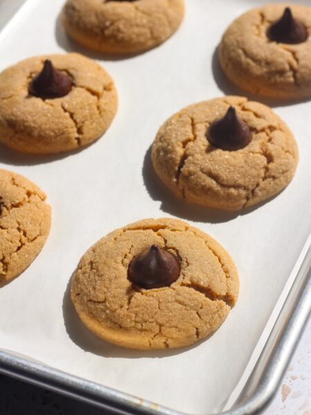 Tray of peanut butter blossoms in direct sunlight.