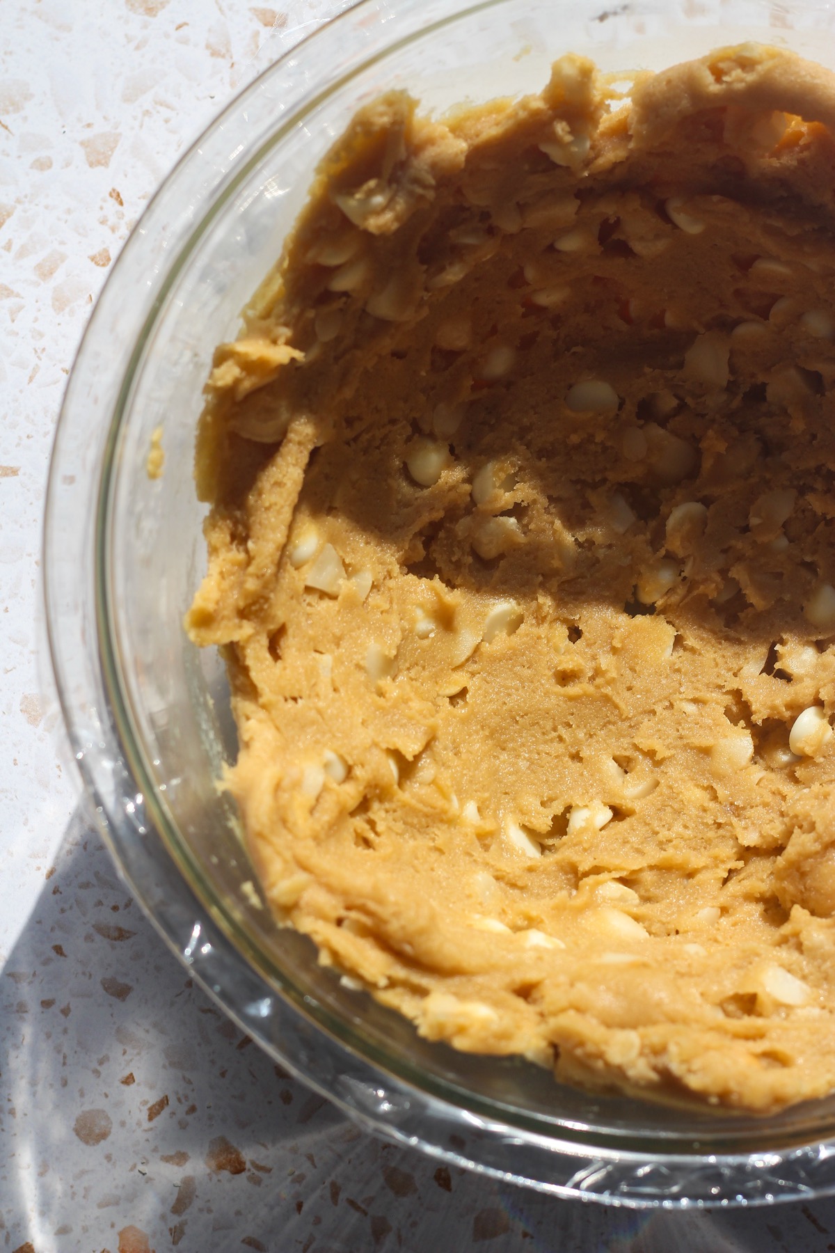 White chocolate macadamia nut cookie dough in a glass bowl.