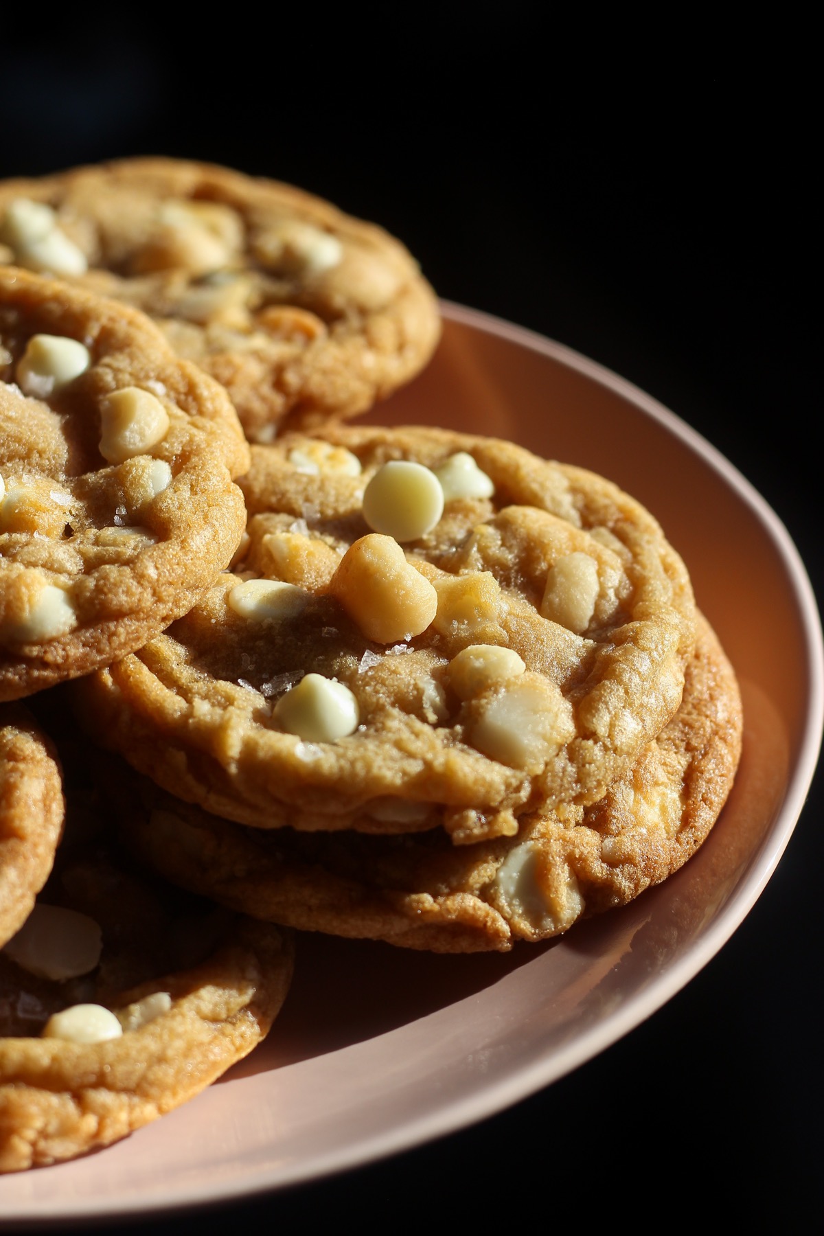 White chocolate macadamia nut cookies on a pink plate.