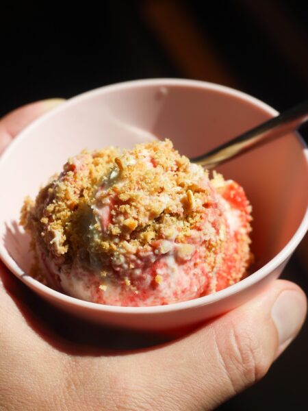 Close up shot of scoopable strawberry cheesecake in a pink bowl