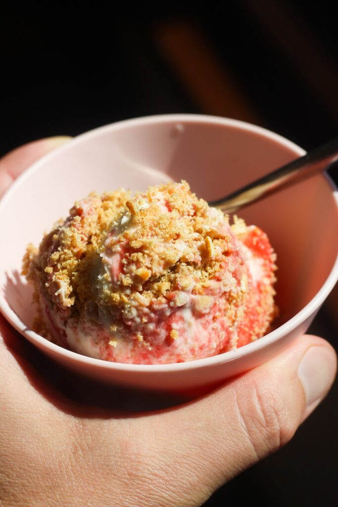 Close up shot of scoopable strawberry cheesecake in a pink bowl