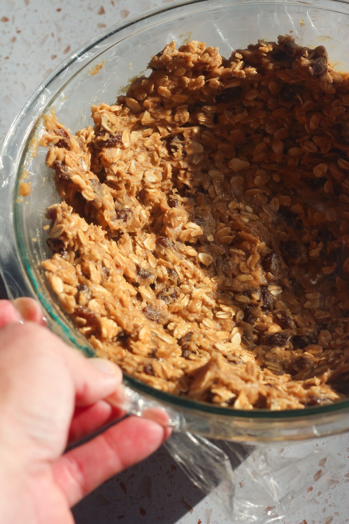 Oatmeal raisin cookie dough fully mixed in a glass bowl