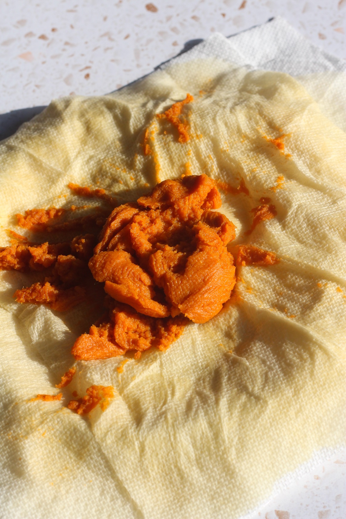 Pumpkin puree blotted on a paper towel to remove excess moisture for brown butter pumpkin oatmeal cookies