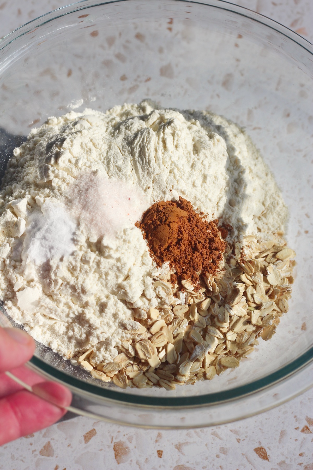 Flour, old-fashioned oats, pumpkin pie spice, salt, and baking soda in a glass mixing bowl