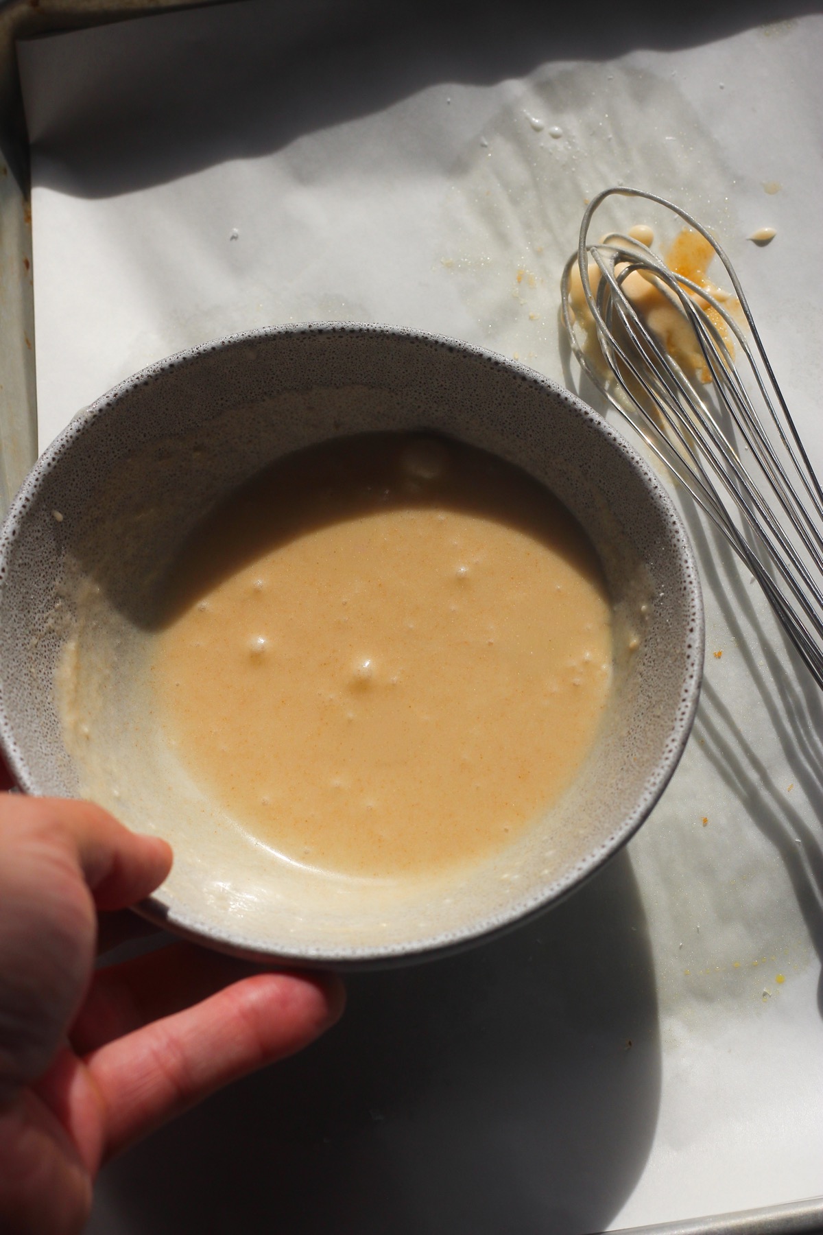 Brown butter icing whisked smooth in a small bowl with a whisk